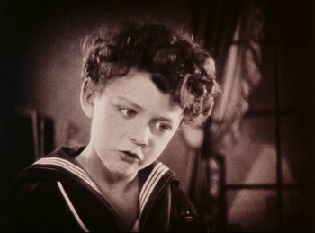 Movie still from “Peter Pan” (1924), directed by Herbert Brenon – A young boy wearing a sailor suit and curly hair; Close Up shot, High angle