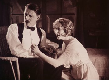 Movie still from “Peter Pan” (1924), directed by Herbert Brenon – A man and a woman sitting in a room; Medium shot, Low angle