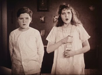 Movie still from “Peter Pan” (1924), directed by Herbert Brenon – Two young children standing next to each other in front of a mirror; Medium shot, Low angle