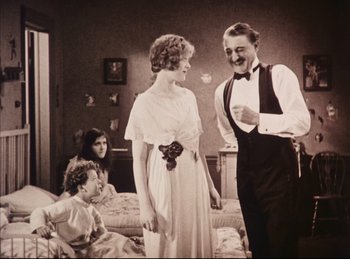 Movie still from “Peter Pan” (1924), directed by Herbert Brenon – A man and a woman standing next to each other in a room; Medium shot, Low angle