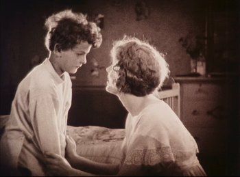 Movie still from “Peter Pan” (1924), directed by Herbert Brenon – An old photo of a woman and a young boy; Medium shot, High angle