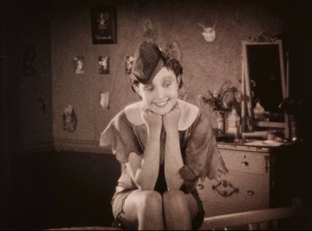 Movie still from “Peter Pan” (1924), directed by Herbert Brenon – An old photo of a woman sitting on a chair; Medium shot, High angle