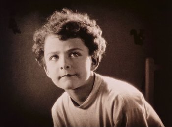 Movie still from “Peter Pan” (1924), directed by Herbert Brenon – A young boy is posing for a picture; Close Up shot, High angle