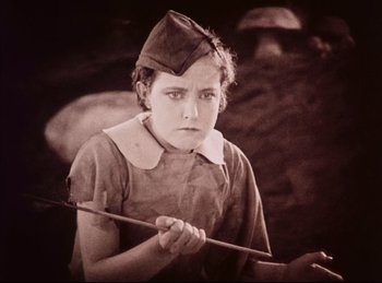 Movie still from “Peter Pan” (1924), directed by Herbert Brenon – An old photo of a girl holding an arrow; Medium shot, High angle