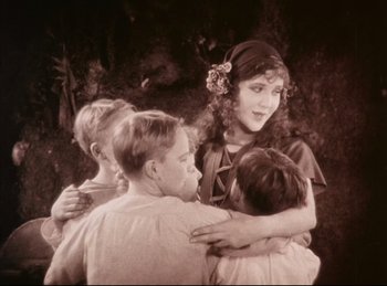 Movie still from “Peter Pan” (1924), directed by Herbert Brenon – A group of children hugging each other in front of a wall; Medium shot, High angle