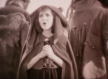 Movie still from “Peter Pan” (1924), directed by Herbert Brenon – An old photo of a young girl in a cloak; Medium shot, Low angle