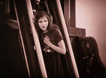 Movie still from “Peter Pan” (1924), directed by Herbert Brenon – A young woman standing next to a wooden structure; Medium shot, Low angle