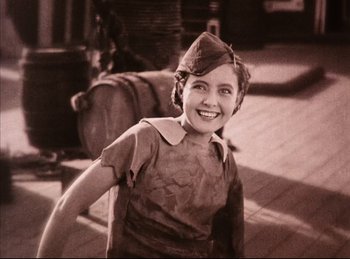 Movie still from “Peter Pan” (1924), directed by Herbert Brenon – An old photo of a woman smiling for the camera; Medium shot, Low angle