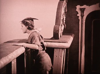 Movie still from “Peter Pan” (1924), directed by Herbert Brenon – An old photo of a woman standing on top of a railing; Medium shot, Low angle