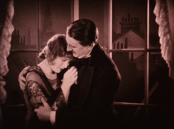 Movie still from “Peter Pan” (1924), directed by Herbert Brenon – A man and a woman embracing in front of a window; Medium shot, Low angle