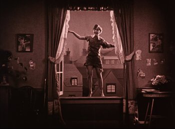 Movie still from “Peter Pan” (1924), directed by Herbert Brenon – A woman standing in front of a large window; Wide shot, Low angle
