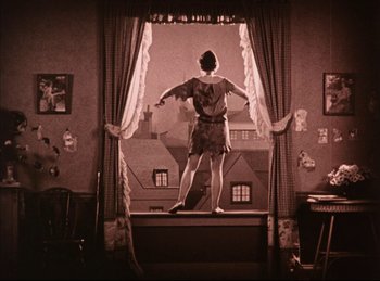 Movie still from “Peter Pan” (1924), directed by Herbert Brenon – A woman standing in front of a large window; Wide shot, Low angle