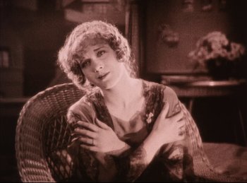 Movie still from “Peter Pan” (1924), directed by Herbert Brenon – An old photo of a woman sitting in a chair with her arms crossed; Medium shot, High angle