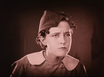 Movie still from “Peter Pan” (1924), directed by Herbert Brenon – An old photo of a young boy wearing a hat; Close Up shot, High angle