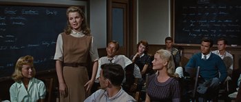 Movie still from “Peyton Place” (1957), directed by Mark Robson – A group of people sitting in a room; Medium shot, Over the shoulder angle