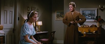 Movie still from “Peyton Place” (1957), directed by Mark Robson – Two women in a room with a lamp on the wall; Medium shot, Over the shoulder angle