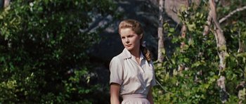 Movie still from “Peyton Place” (1957), directed by Mark Robson – A woman in a white dress standing in front of a tree; Medium shot, Low angle