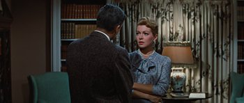 Movie still from “Peyton Place” (1957), directed by Mark Robson – A man and a woman are standing in front of a lamp; Medium shot, Over the shoulder angle