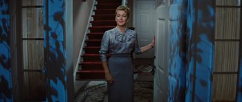 Movie still from “Peyton Place” (1957), directed by Mark Robson – A woman standing in front of a door way; Medium shot, Low angle