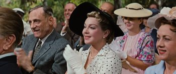 Movie still from “Peyton Place” (1957), directed by Mark Robson – A woman wearing a black hat and a white polka dot dress; Close Up shot, Over the shoulder angle
