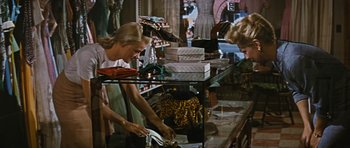 Movie still from “Peyton Place” (1957), directed by Mark Robson – Two women are shopping in a clothing store; Medium shot, High angle