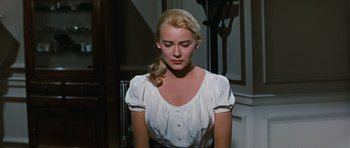 Movie still from “Peyton Place” (1957), directed by Mark Robson – A woman in a white dress sitting in front of a mirror; Close Up shot, High angle