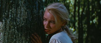 Movie still from “Peyton Place” (1957), directed by Mark Robson – A woman leaning against a tree in the woods; Close Up shot, Low angle