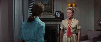 Movie still from “Peyton Place” (1957), directed by Mark Robson – Two women are standing in front of a fireplace; Medium shot, Over the shoulder angle