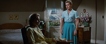 Movie still from “Peyton Place” (1957), directed by Mark Robson – Two women are standing in front of a window; Medium shot, Over the shoulder angle