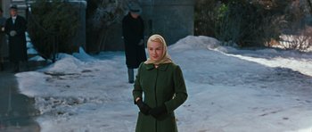 Movie still from “Peyton Place” (1957), directed by Mark Robson – A woman in a green coat and a scarf; Medium shot, Over the shoulder angle