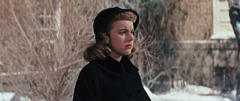 Movie still from “Peyton Place” (1957), directed by Mark Robson – A woman in a black coat and a black hat; Close Up shot, Low angle