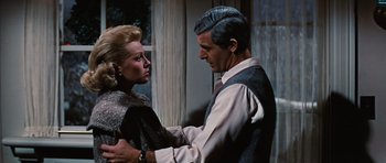 Movie still from “Peyton Place” (1957), directed by Mark Robson – A man and a woman standing next to each other in front of a window; Close Up shot, Over the shoulder angle