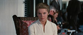 Movie still from “Peyton Place” (1957), directed by Mark Robson – A woman in a white shirt is sitting in a chair; Close Up shot, Over the shoulder angle