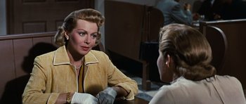 Movie still from “Peyton Place” (1957), directed by Mark Robson – A woman sitting in front of another woman in front of a wooden table; Close Up shot, Over the shoulder angle