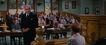 Movie still from “Peyton Place” (1957), directed by Mark Robson – A group of people sitting at a table in a courtroom; Wide shot, Low angle