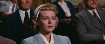 Movie still from “Peyton Place” (1957), directed by Mark Robson – An older woman wearing a white head scarf and a blue sweater; Close Up shot, Over the shoulder angle