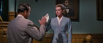Movie still from “Peyton Place” (1957), directed by Mark Robson – A man and a woman are standing in front of a painting; Medium shot, Over the shoulder angle