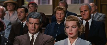 Movie still from “Peyton Place” (1957), directed by Mark Robson – A man and a woman are sitting in front of a crowd; Close Up shot, Over the shoulder angle