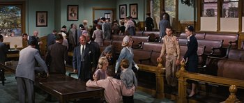 Movie still from “Peyton Place” (1957), directed by Mark Robson – A group of people standing in a room; Wide shot, High angle