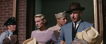 Movie still from “Peyton Place” (1957), directed by Mark Robson – A group of people standing next to each other in a room; Medium shot, Low angle