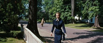 Movie still from “Peyton Place” (1957), directed by Mark Robson – A woman walking down the street holding a purse; Wide shot, Low angle