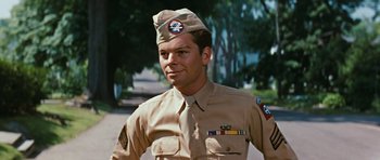 Movie still from “Peyton Place” (1957), directed by Mark Robson – A man in a military uniform standing in front of trees; Close Up shot, Low angle