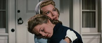Movie still from “Peyton Place” (1957), directed by Mark Robson – A woman and a young girl embracing each other; Close Up shot, Low angle