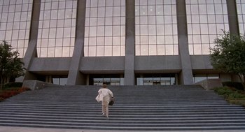 Movie still from “Phantom of the Paradise” (1974), directed by Brian De Palma – A person walking up some steps in front of a building; Extreme Wide shot, Low angle