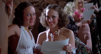 Movie still from “Phantom of the Paradise” (1974), directed by Brian De Palma – Two young women are holding papers and smiling; Close Up shot, High angle