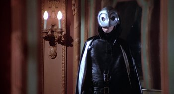 Movie still from “Phantom of the Paradise” (1974), directed by Brian De Palma – A man in a leather suit and mask stands in front of a mirror; Medium shot, Low angle