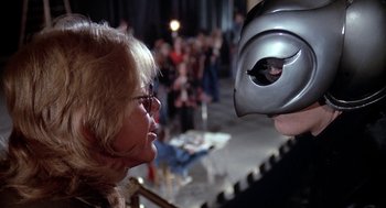 Movie still from “Phantom of the Paradise” (1974), directed by Brian De Palma – A woman looking at a man with a mask on; Close Up shot, Over the shoulder angle