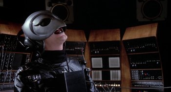 Movie still from “Phantom of the Paradise” (1974), directed by Brian De Palma – A person wearing a helmet in front of a sound board; Close Up shot, Low angle