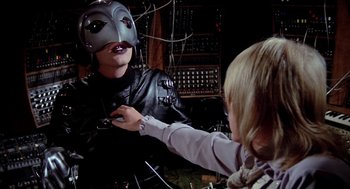 Movie still from “Phantom of the Paradise” (1974), directed by Brian De Palma – A person wearing a helmet and a leather jacket; Close Up shot, Over the shoulder angle