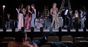 Movie still from “Phantom of the Paradise” (1974), directed by Brian De Palma – A group of people on a stage with a band; Wide shot, Low angle